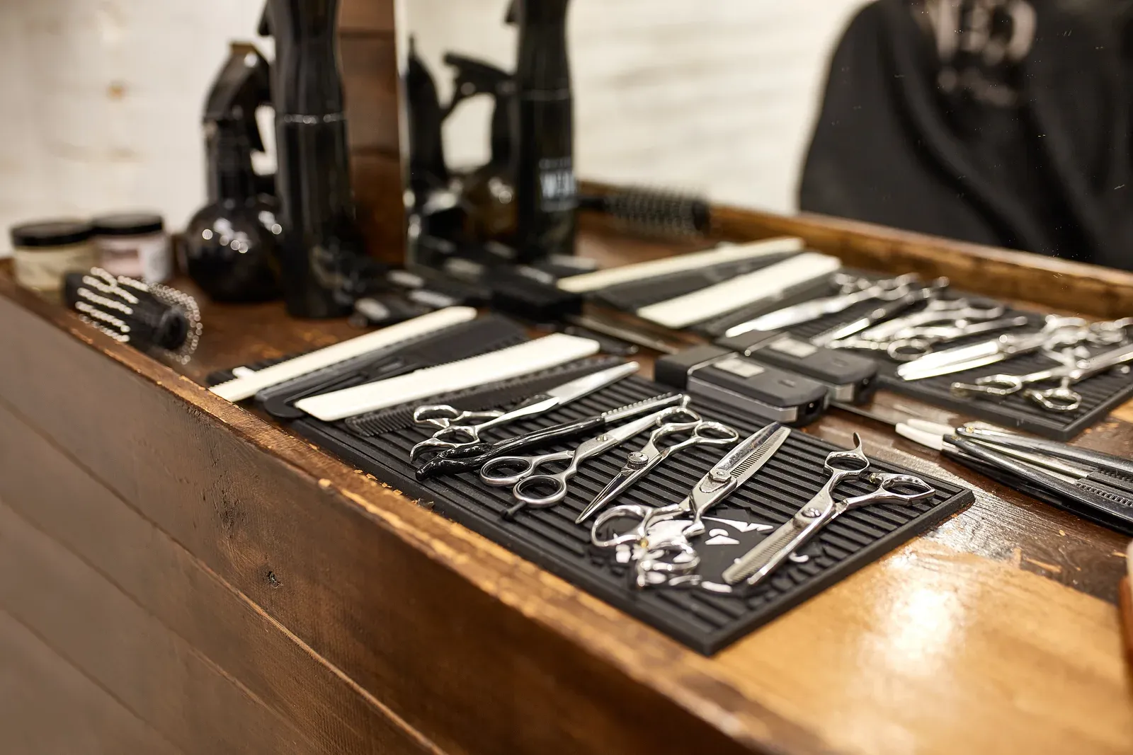 Scissors, combs and clippers laid out on a barber’s station