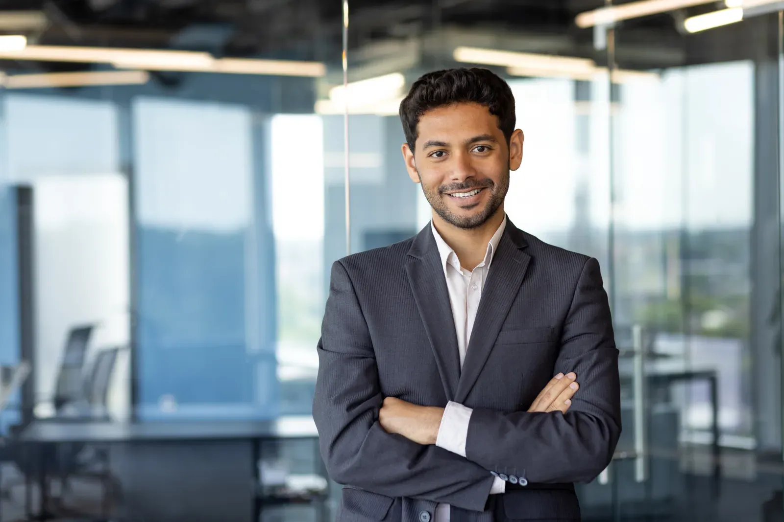 Smiling man in a suit with short, neatly styled hair in an office